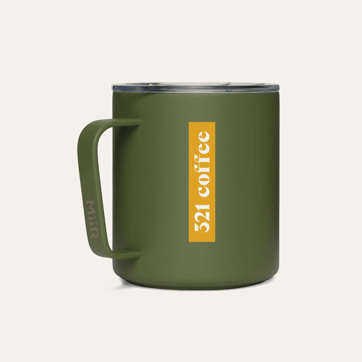 The back of a dark green metal camp mug with "321 Coffee" printed in white on a yellow background on the mug.