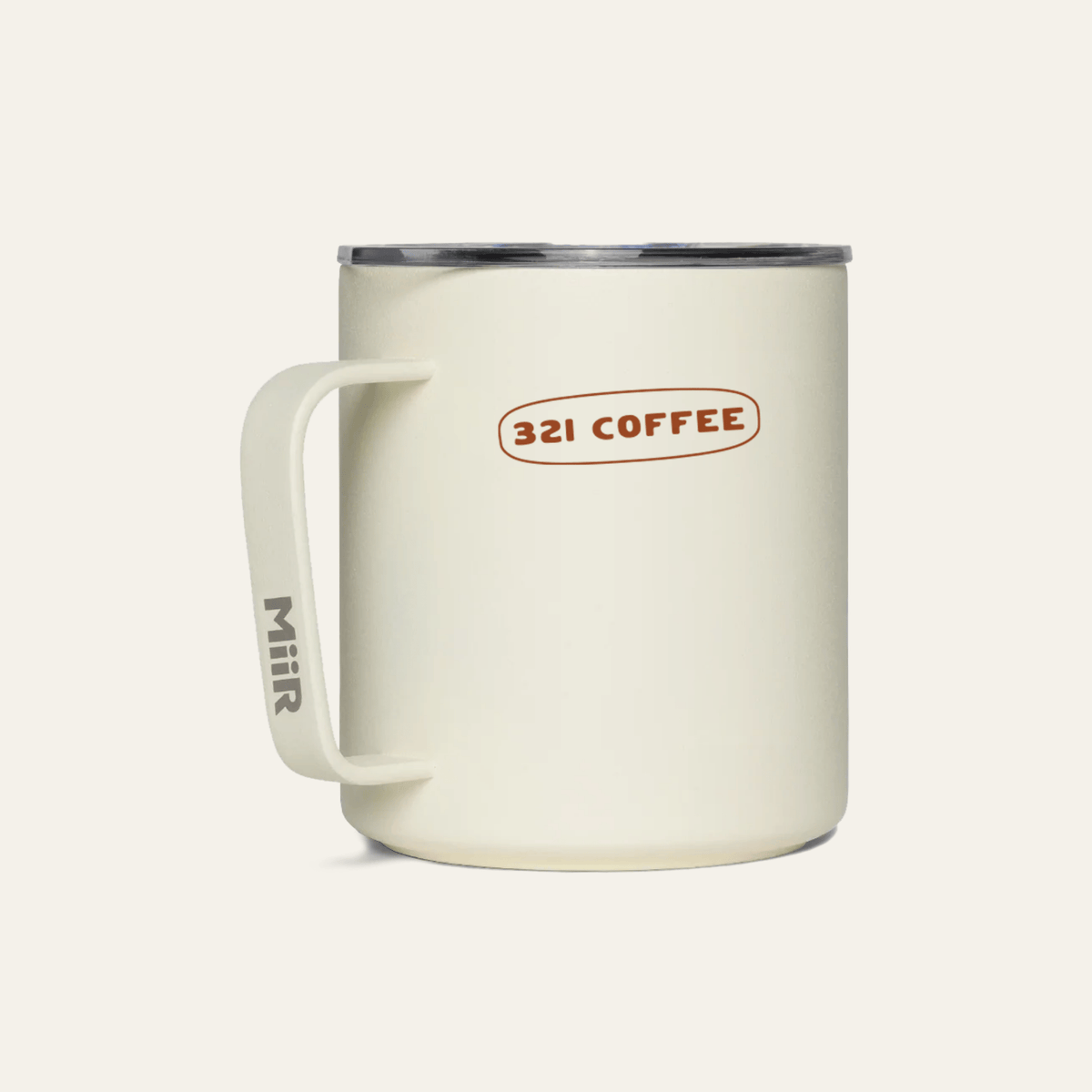 The back of a light beige metal camp mug with "321 Coffee" printed in maroon.