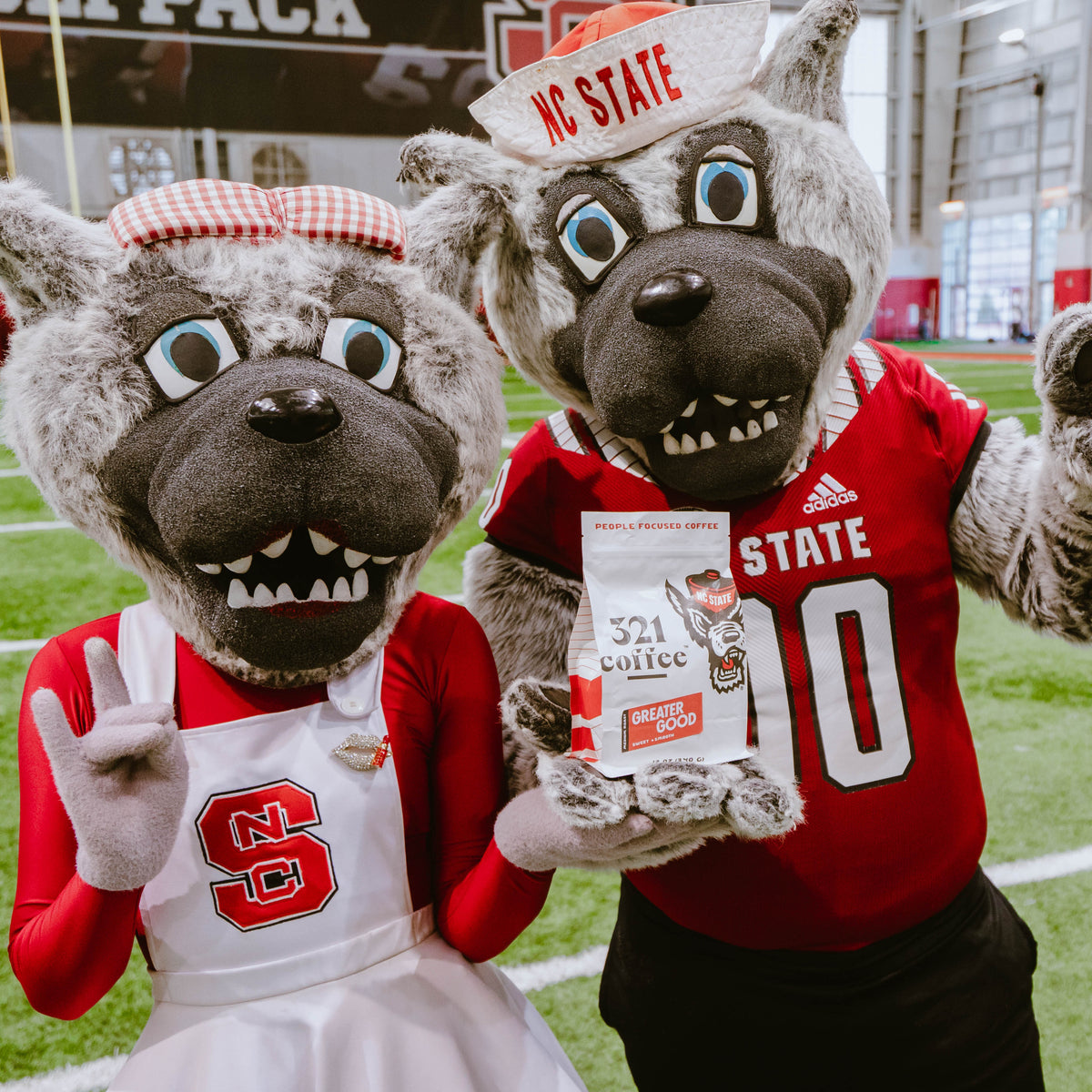 Mr. and Ms. Wuf, the NC State Wolfpack mascots, hold a bag of 321 Coffee Greater Good roast together at the reveal event.