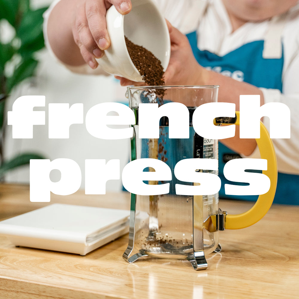 White text that reads "French press" overlays an image of a barista pouring coffee grounds into a French press.