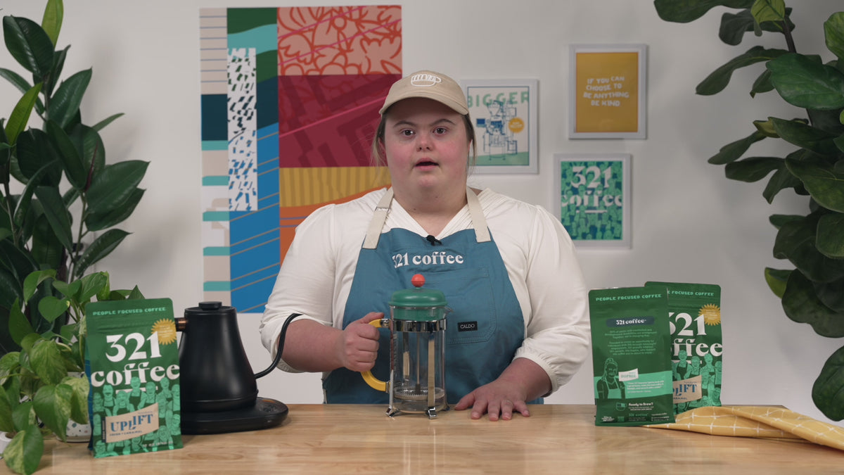 Sophie, a 321 Coffee barista, introduces the French press brew guide and says, "Hi, I'm Sophie and I'm going to show you how to brew a French press with my dark roast."